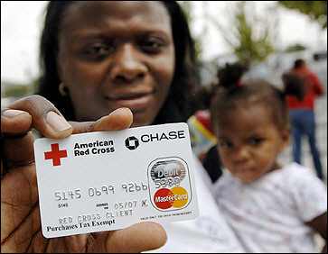 Hurricane Katrina evacuee Latesha Vinnett holds a debit card from the Red Cross with her daughter Mychal Boykins outside the Reliant Center in Houston, Texas.(AFP/Stan Honda)